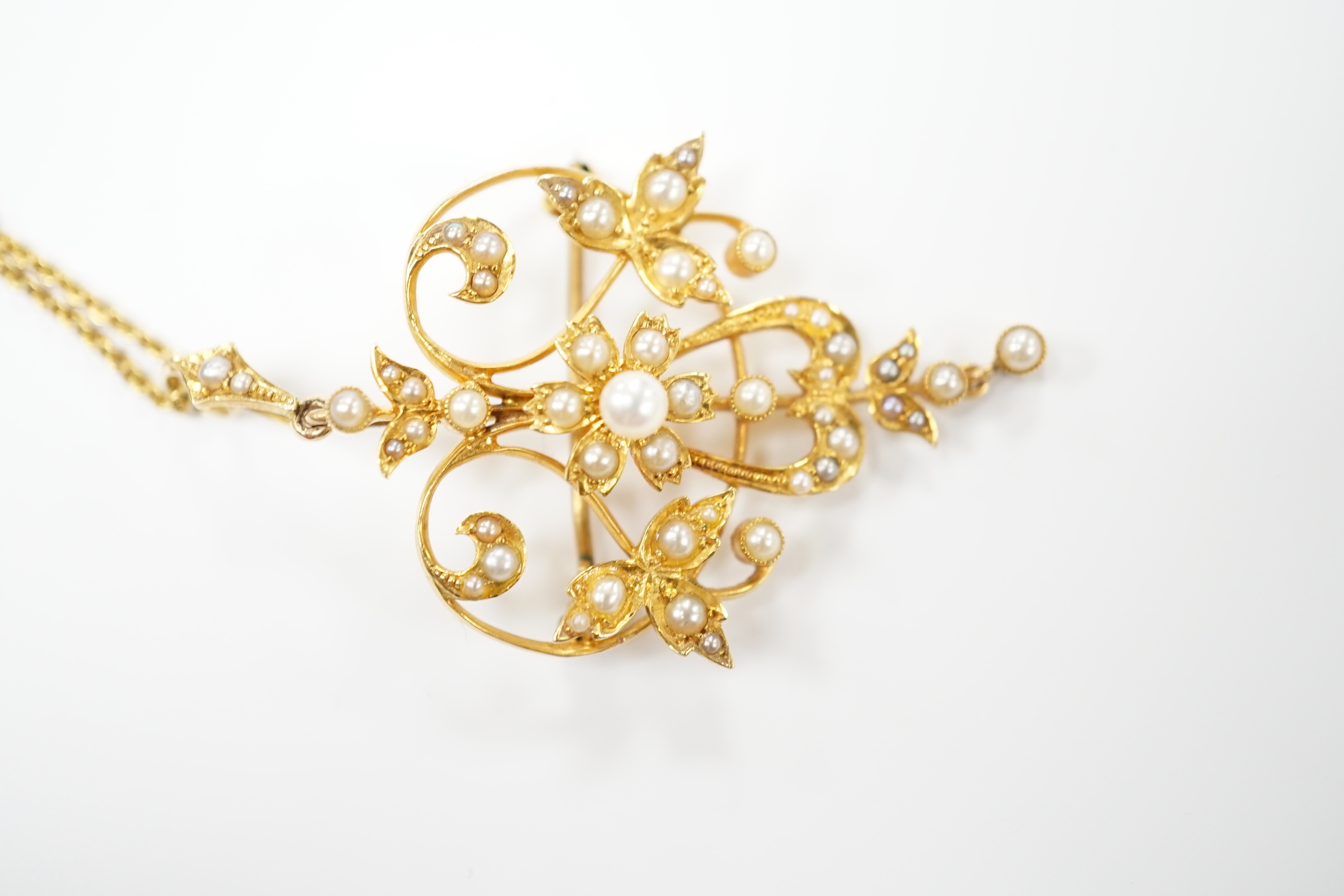 An Edwardian 15ct and seed pearl cluster set drop pendant brooch, 40mm on a later 375 chain.
